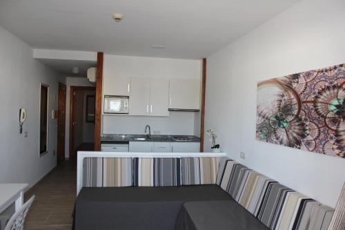 a living room with a couch and a kitchen at Venecia Apartments in Port d'Alcudia
