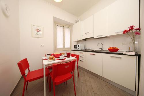 ローマにあるGreat Central Apartmentの赤い椅子とテーブル、カウンター付きのキッチン