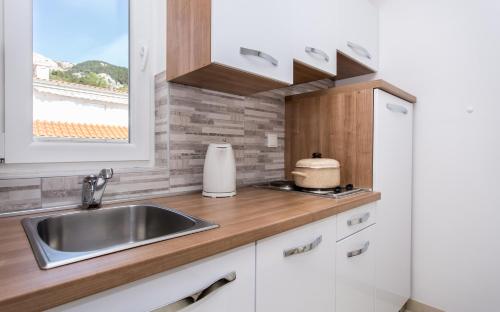 a kitchen with a sink and a window at Apartments Mira in Baška