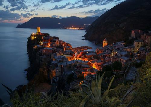 a city at sunset with a large body of water at Santa Marta Rooms - Via Roma 23 in Vernazza