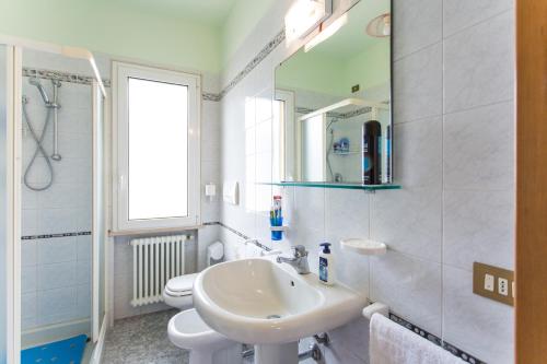 a bathroom with a sink and a toilet and a mirror at Residence Kimba in Rimini