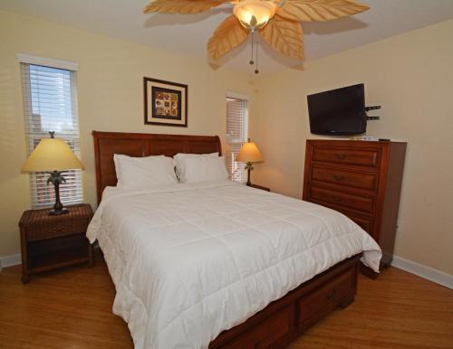 een slaapkamer met een bed en een plafondventilator bij Westwinds Waterfront Resort in St Pete Beach