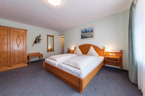 una camera da letto con un grande letto con lenzuola bianche di Zum Fässle a Hagnau