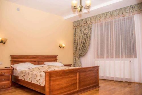 a bedroom with a wooden bed and a window at Pensiunea Maria in Fîrdea