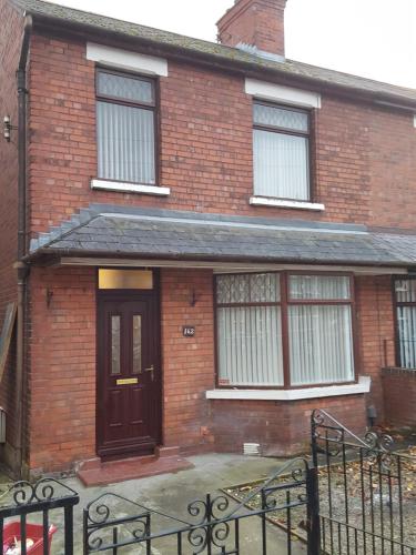 a brick house with a brown door and windows at Alexandra Park House in Belfast