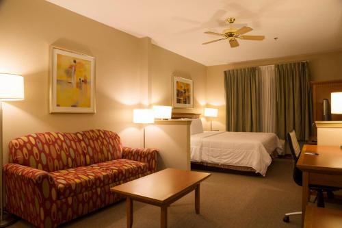 a hotel room with a couch and a bed at Brawley Inn in Brawley