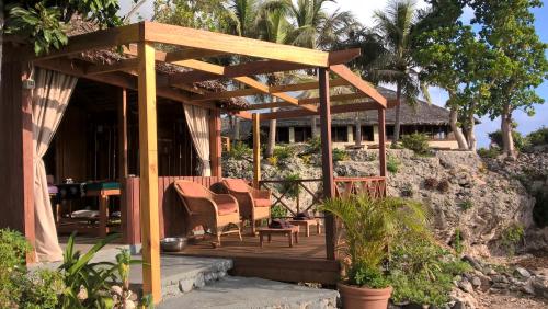 a wooden deck with chairs and a house at White Grass Ocean Resort & Spa in Tanna Island
