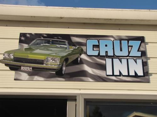 a sign on the side of a building with a car on it at Cruz Inn in Featherston