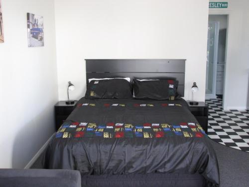 1 dormitorio con 1 cama con edredón negro en Cruz Inn, en Featherston