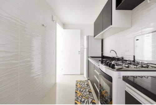 cocina blanca con fogones y fregadero en Top Floripa Apartment, en Florianópolis
