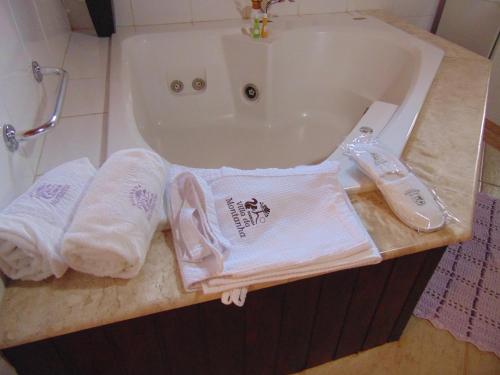 a bathroom with two towels and a bath tub at Pousada Villa Da Montanha in São Bento do Sapucaí