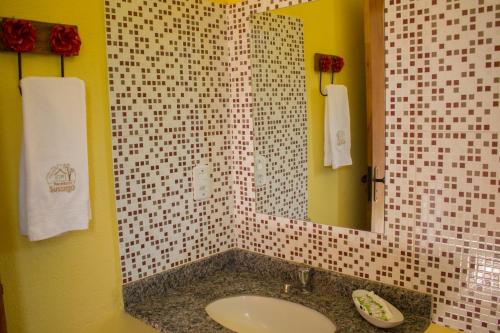 a bathroom with a sink and a mirror at Pousada Recanto Do Sussego in Olímpia