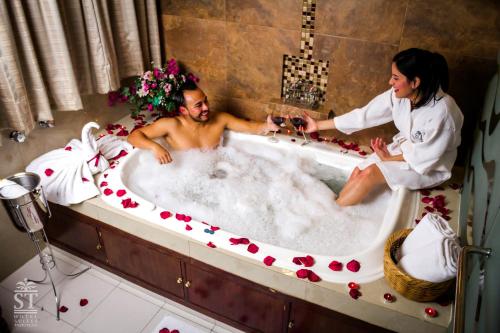 un hombre y una mujer sentados en una bañera con vino en Hotel Suites Teziutlan, en Teziutlán