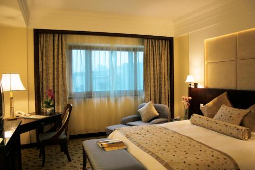 a hotel room with a bed and a desk and a desk at The Presidential Beijing in Beijing