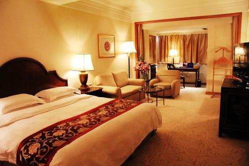 a hotel room with a bed and a living room at The Presidential Beijing in Beijing
