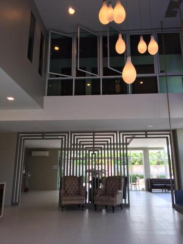 a living room with two chairs and some lights at Embryo Hotel  in Pattaya Central