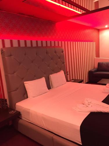 - une chambre avec un grand lit et un éclairage rouge dans l'établissement Intimisimo Autohotel Adults Only Ciudad Industrial, à Veracruz