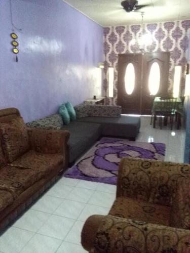 a living room with a couch and a table at Deenaz Utara Homestay in Alor Setar