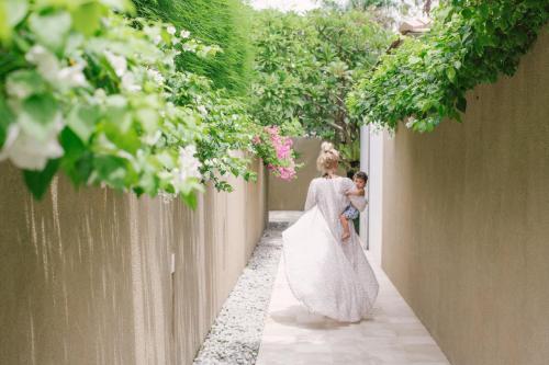 a woman holding a little girl in a wedding dress at Uma Sapna Seminyak in Seminyak
