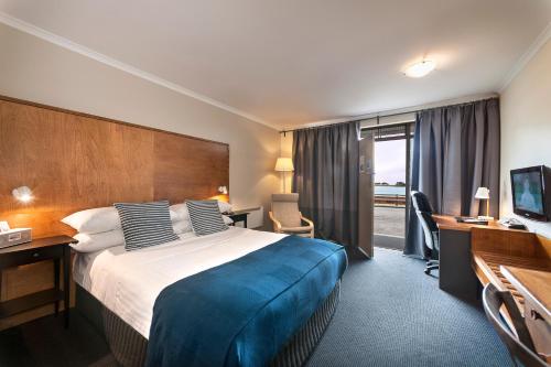 ウィンヤードにあるThe Waterfront Wynyardの大きなベッドとテレビがあるホテルの部屋