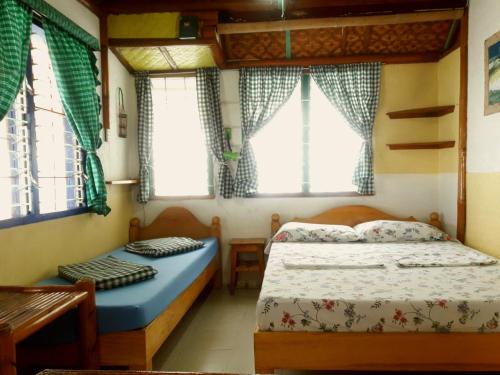 a bedroom with two beds in a house at Casa de la Playa Beach Resort in Siquijor