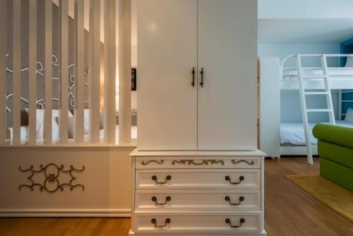 a bedroom with a dresser and a bunk bed at Yan's House Hotel in Kuta
