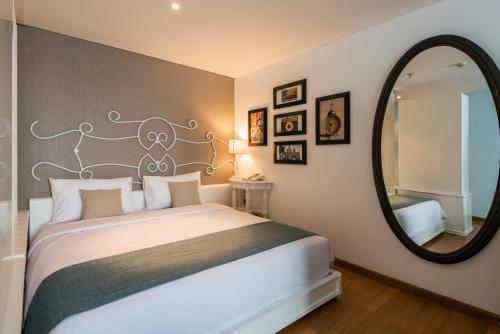 a bedroom with a large bed with a large mirror at Yan's House Hotel in Kuta