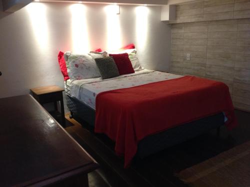 a bedroom with a bed with a red blanket at Angel Ilha Flats e Varanda da Praia in Abraão
