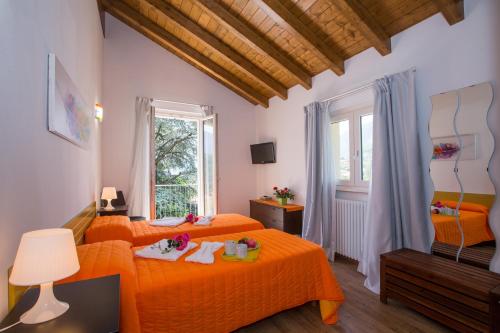 a bedroom with two beds with orange sheets at Lenno Dolcelago in Lenno