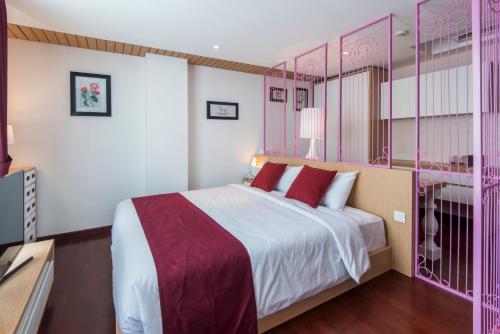 a bedroom with a large bed with red pillows at Yan's House Hotel in Kuta