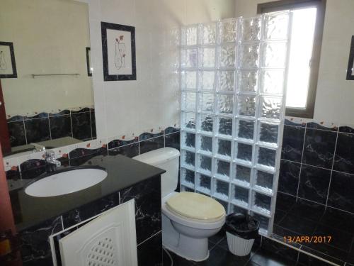 Un baño con inodoro, lavabo y espejo. en Thai Paradise South 255/2, en Cha Am