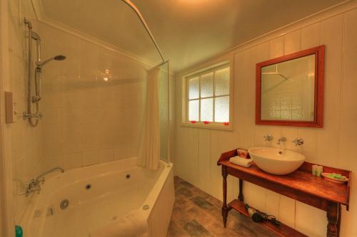 a bathroom with a white tub and a sink at Grace's Spa Cottage in Smithton