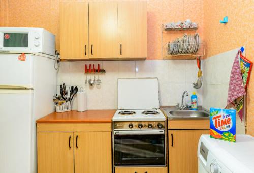 a small kitchen with a stove and a sink at Apartment TwoPillows on Lenina 56 in Vorkuta