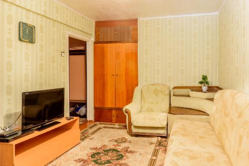 a living room with a couch and a television at Apartment TwoPillows on Lenina 56 in Vorkuta