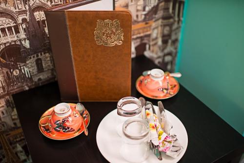 a book and two cups and plates on a table at Hotel X.O in Novosibirsk