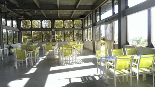 a room with yellow chairs and tables and windows at Yulan Green Roof in Datong