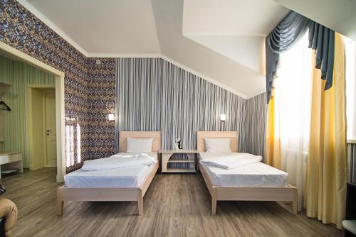a room with two beds in a room with a wall at Hotel X.O in Novosibirsk