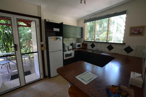 a kitchen with a refrigerator and a counter top at Shambhala Retreat Magnetic Island Cottages in Nelly Bay