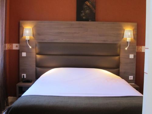 a bedroom with a large white bed with two lights at Logis Deshors-Foujanet in Chamboulive