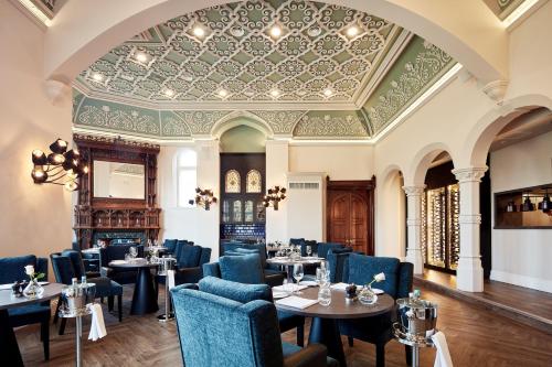 a restaurant with tables and chairs and a ceiling at Oddfellows On The Park in Cheadle