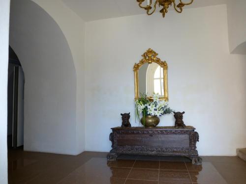 a table with a mirror and a vase with flowers at Schloss Hotel Wallhausen in Wallhausen