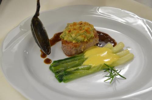 a plate of food with a piece of meat and asparagus at Castell Hotel & Restaurant in Leinsweiler