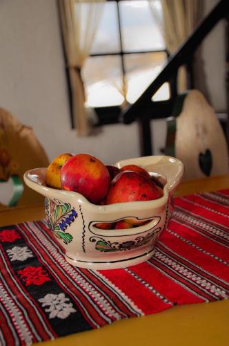 a bowl of apples sitting on a table at Casuta Bunicii in Bran