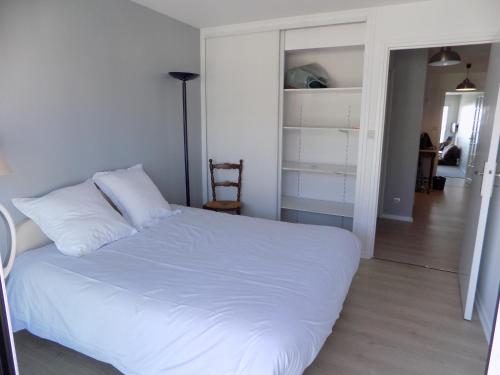 ヴィムルーにあるLe Grand Bleuのベッドルーム1室(白いベッド1台付)、廊下が備わります。