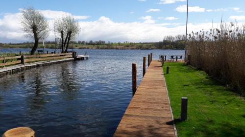 a dock on a body of water with trees at Hotel Villa Passion in Malchow