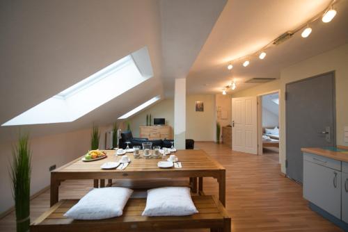 eine Küche und ein Wohnzimmer mit einem Tisch und einem Dachfenster in der Unterkunft Rheinauer Hof - bed & breakfast in Mannheim
