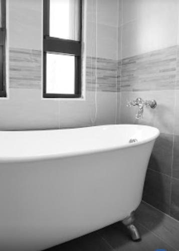 a white bath tub in a bathroom with a window at Warm Home in Taitung City