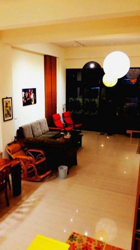 a living room with a couch and red chairs at Warm Home in Taitung City