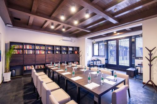 a large room with a long table and chairs at Pingyao Elsewhere Gongji Hotel in Pingyao