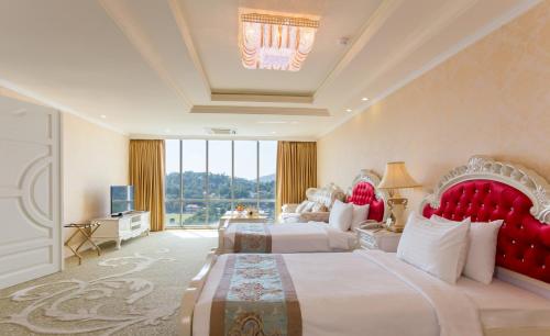 a hotel room with two beds and a television at The Grand Kandyan in Kandy